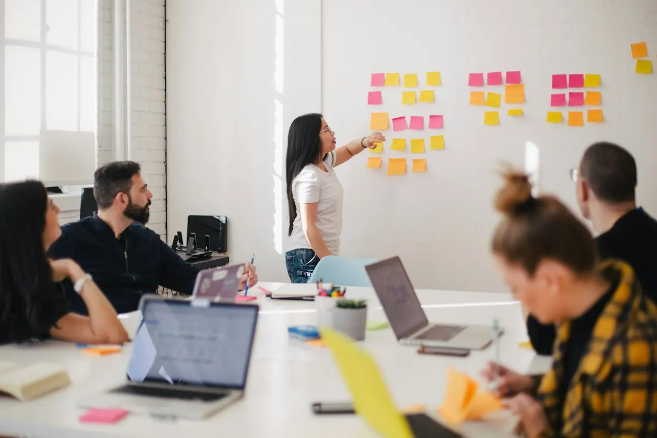 A marketing team planning a campaign together around a wall of notes