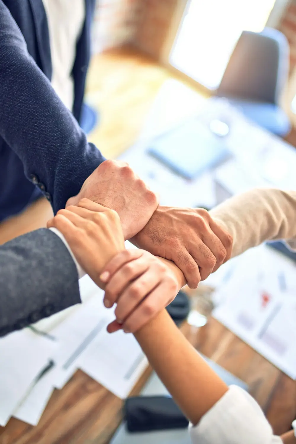 Colleagues joining hands as a sign of teamwork and partnership
